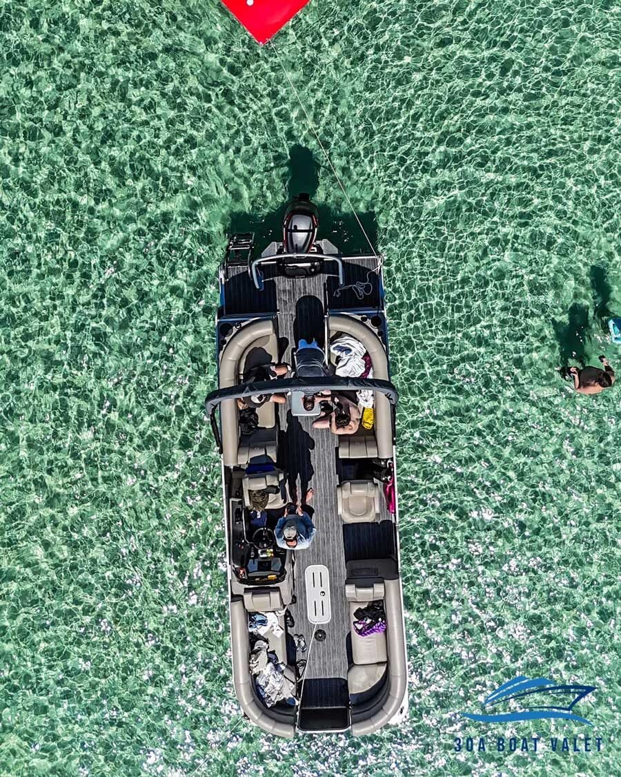 Top-down drone view of the luxury tritoon pontoon on emerald water at Crab Island